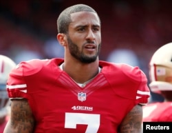 FILE - San Francisco 49ers quarterback Colin Kaepernick stands on the field before their NFL pre-season football game against the Denver Broncos in San Francisco, California.