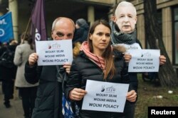FILE - Demonstrators hold banners "Free Parliamnent, Free Media, Free Poles" during a protest in Gdansk, Poland, Dec. 17, 2016.