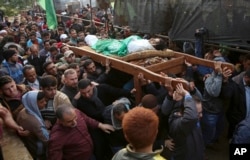 Mourners carry the body of Palestinian fisherman Nawaf Al-Attar, 20, who was shot and killed by Israeli troops on the beach near the border with Israel, during his funeral in Beit Lahiya, northern Gaza Strip, Nov. 14, 2018.