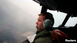 Co-Pilot, Flying Officer Marc Smith, turns his Royal Australian Air Force (RAAF) AP-3C Orion aircraft at low level in bad weather whilst searching for the missing Malaysian Airlines Flight MH370 over the southern Indian Ocean, March 24, 2014.