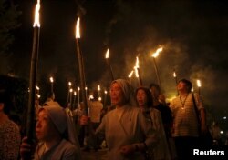 Catholics holding torches leave Urakami Cathedral for a peace march to the Peace Park in Nagasaki, western Japan, on the 70th anniversary of the bombing of Nagasaki, Aug. 9, 2015.