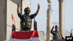 Members of Iraq's elite counter-terrorism service flash the "V" for victory sign, Dec. 29, 2015, in the city of Ramadi, the capital of Iraq's Anbar province, about 110 kilometers west of Baghdad, after Iraqi forces recaptured it from the Islamic State group.