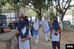 School students try to protect themselves from the dirty air in Delhi, Nov. 8, 2017. (A. Pasricha/VOA)
