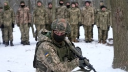 An instructor trains members of Ukraine's Territorial Defense Forces, volunteer military units of the Armed Forces, in a city park in Kyiv, Ukraine, Saturday, Jan. 22, 2022. (AP Photo/Efrem Lukatsky)