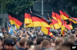 Demonstranti nose nemačke zastave tokom okupljanja u Kemincu, istočna Nemačka, 1. septembra 2018.