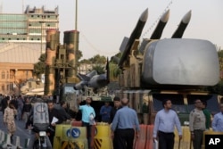 A Russian-made S-300 air defense system, left, is on display for the annual Defense Week, marking the 37th anniversary of the 1980s Iran-Iraq war, at Baharestan Sq. in Tehran, Iran, Sunday, Sept. 24, 2017.