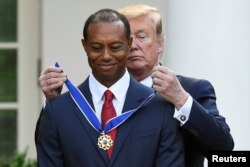 도널드 트럼프 미국 대통령이 6일 백악관 로즈가든에서 '골프황제' 타이거 우즈에에게 대통령 자유메달을 수여하고 있다.