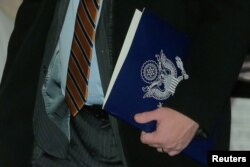 A member of the U.S. trade delegation to China, carries a folder as he leaves a hotel in Beijing, Jan. 7, 2019.