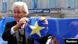 Dutch far-right Freedom Party leader Geert Wilders holds a star he cut from a European Union flag during a Eurosceptic rally in front of the EU Parliament in Brussels, Belgium, May 20, 2014.