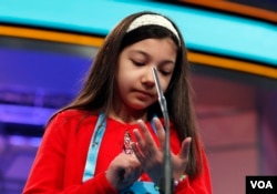 Melodie Loya, 12, from Bainbridge, N.Y., uses her hand as and imaginary paper and pen to spell her word during the finals of the 90th Scripps National Spelling Bee, Thursday, June 1, 2017, in Oxon Hill, Md. (AP Photo/Alex Brandon)