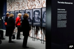 People look at a section of the "Americans" exhibit that explores the historical context of the Trail of Tears, at the Smithsonian's National Museum of the American Indian, Friday, Feb. 9, 2018