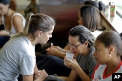 A woman is comforted by a volunteer as she waits for informations about missing relatives, after a dam collapsed in Brumadinho, Brazil, Jan. 26, 2019. The Brazilian mining company Vale SA CEO Fabio Schvartsman said he did not know what caused the collapse.