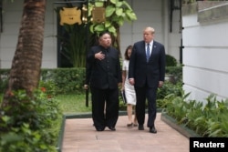 North Korea's leader Kim Jong Un and U.S. President Donald Trump talk in the garden of the Metropole hotel during the second North Korea-U.S. summit in Hanoi, Vietnam Feb. 28, 2019.
