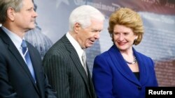 U.S. Senate Agriculture Committee Chairman Debbie Stabenow (D-MI) smiles with ranking member Senator Thad Cochrane (R-MI) (C) at a news conference after the final passage of the Farm Bill at the U.S. Capitol in Washington, Feb. 4, 2014.