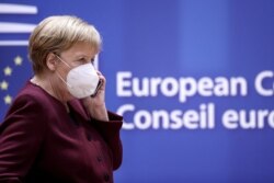 Germany's Chancellor Angela Merkel, wearing a face mask, speaks on the phone as she attends a two-day face-to-face EU summit, in Brussels, Belgium October 16, 2020. Kenzo Tribouillard/Pool via REUTERS