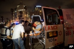 FILE - A wounded man is evacuated from the scene of a stabbing attack in Jaffa, a mixed Jewish-Arab part of Tel Aviv, Israel, March 8, 2016.