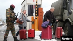 A Belgian soldier accompanies passengers at Brussels' Zaventem airport following Tuesday's bomb attacks in Brussels, March 23, 2016.