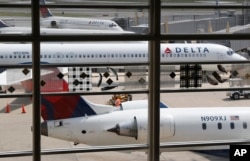 FILE - Delta Air Lines planes are parked at Ronald Reagan Washington National Airport, in Washington, Aug. 8, 2016.