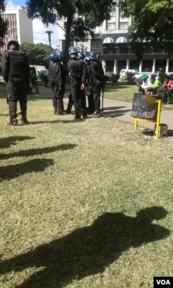 Police attempt to remove protesters from Africa Unity Square in Harare.