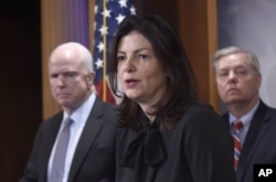 FILE - Sen. Kelly Ayotte, R-N.H., center, flanked chairman Sen. John McCain, R-Ariz., left, and Sen. Lindsey Graham, R-S.C., speaks during a news conference on Capitol Hill.