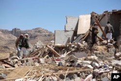 FILE - People inspect the rubble of a house destroyed by a Saudi-led airstrike in the outskirts of Sana'a, Yemen, Feb. 16, 2017.