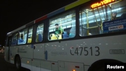 People are shown on an official media bus after its window was shattered while driving journalists to the Main Transport Mall from the Deodoro Stadium of the Rio 2016 Olympic Games in Rio de Janeiro, Aug. 9, 2016.