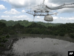 FILE - The world's largest single-dish radio telescope at the Arecibo Observatory in Arecibo, Puerto Rico, photographed July 13, 2016. Dwindling funds from the U.S. government and construction of bigger, more powerful telescopes are threatening this telescope's future.