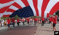 4일 캘리포니아주 산타모니카 독립기념일 행사 참가자들이 대형 성조기를 펼쳐들고 행진하고 있다.