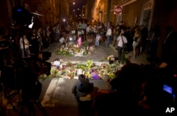 FILE - Television lights illuminate a makeshift memorial in Charlottesville, Va., Sunday, Aug. 13, 2017, during a vigil held at the site where a car plowed into a crowd of people protesting a white nationalist rally on Saturday in Charlottesville, Virginia.