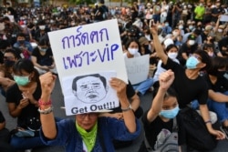 A protester holds a sign depicting Thai Prime Minister Prayuth Chan-Ocha during a protest demanding the resignation of the government.