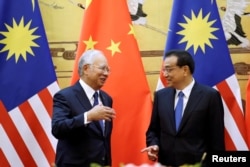 FILE - Malaysia's Prime Minister Najib Razak and China's Premier Li Keqiang attend a signing ceremony at the Great Hall of the People, in Beijing, China, Nov. 1, 2016.