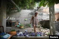 Felina, 50, an indigenous Zapotec 'muxe,' walks on the crockery inside her house destroyed after an earthquake in Juchitan, Sept. 10, 2017.
