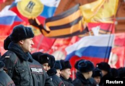 FILE - Policemen stand in front of participants of an "Anti-Maidan" rally against the 2014 Kyiv uprising, which ousted President Viktor Yanukovych, in Moscow, Feb. 21, 2015.