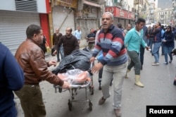 Egyptians rush the body a victim to an ambulance after a suicide bombing in front of a church in Alexandria, Egypt, April 9, 2017.