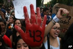 FILE - People protest the disappearance of 43 students in Mexico City earlier this month.