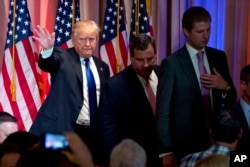 Republican presidential candidate Donald Trump, accompanied by New Jersey Gov. Chris Christie, center, and his son Eric Trump, right, depart after speaking during a news conference on Super Tuesday primary election night in the White and Gold Ballroom at