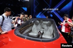 Journalists visit a Volkswagen I.D. concept car at a media event ahead of the Beijing Auto Show in Beijing, China, April 24, 2018.
