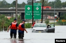 Members of the Coast Guard help a stranded motorist in the flood waters caused by Hurricane Florence in Lumberton, North Carolina, Sept. 16, 2018.