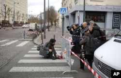 Watched by the media a woman lays a flower tribute at the site of the attack on a kosher market in Paris, France, Jan. 10, 2015.
