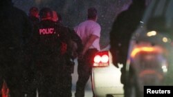 FILE - Police put the man suspected of killing at least three people during a shooting at a Planned Parenthood clinic in Colorado Springs, Colorado, into a police vehicle, Nov. 27, 2015.