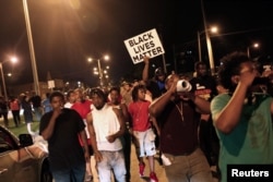 Protesters march during disturbances following the police shooting of a man in Milwaukee, Wisconsin, Aug. 14, 2016.