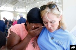 April Moore of Gulfport, left, cries after thanking Anne Warren of Gulf Coast Blessings for prayers from her Bible group following a Katrina 10 Year Remembrance in Gulfport, Miss., Aug. 29, 2015.