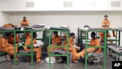 FILE - Inmates hang out on their bunks in a unit in the Harris County Jail for gay, bisexual and transgender inmates in Houston, Texas, Dec. 10, 2013.