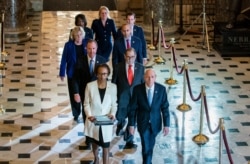 Clerk of the House Cheryl Johnson, left, and House Sergeant at Arms Paul Irving pass through Statuary Hall at the Capitol to deliver the articles of impeachment against President Donald Trump to Senate, Jan. 15, 2020.
