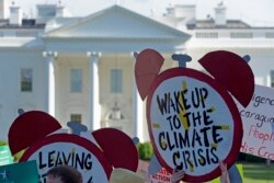 FILE- Protesters gather outside the White House in Washington to protest President Donald Trump's decision to withdraw the Unites States from the Paris climate change accord, June 1, 2017.