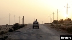 FILE - An Egyptian military vehicle is seen on a highway in northern Sinai, Egypt, May 25, 2015.