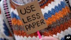 Seorang demonstran di Lisabon, Portugal menyerukan dikuranginya penggunaan kertas (yang berarti berkurangnya pohon yang ditebang) untuk memerangi peningkatan suhu Bumi, dalam aksi hari Jumat (29/11). 