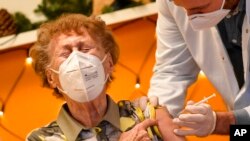 FILE - A resident of a nursing home reacts as she gets an injection of the COVID-19 vaccine in Cologne, Germany, Dec. 27, 2020. 