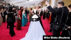 FILE - Greta Gerwig embraces Saoirse Ronan on the red carpet during the Oscars arrivals at the 92nd Academy Awards in Hollywood, Los Angeles, California, U.S., February 9, 2020. (REUTERS/Mike Blake/File Photo)