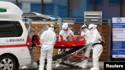 一位确诊感染冠状病毒的病人在韩国春川被推进一家医院（2020年2月20日）。